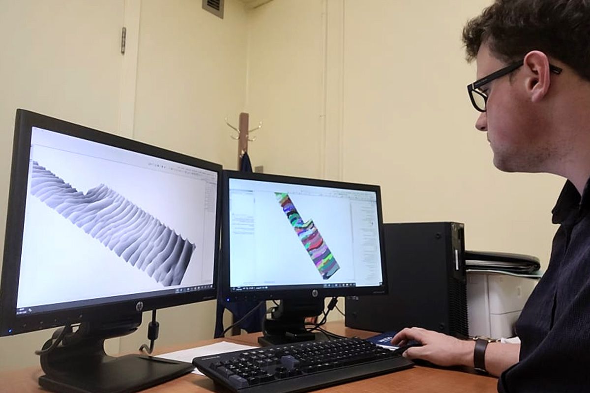 Étudiant regardant deux écrans d'ordinateur affichant un dessin 3D