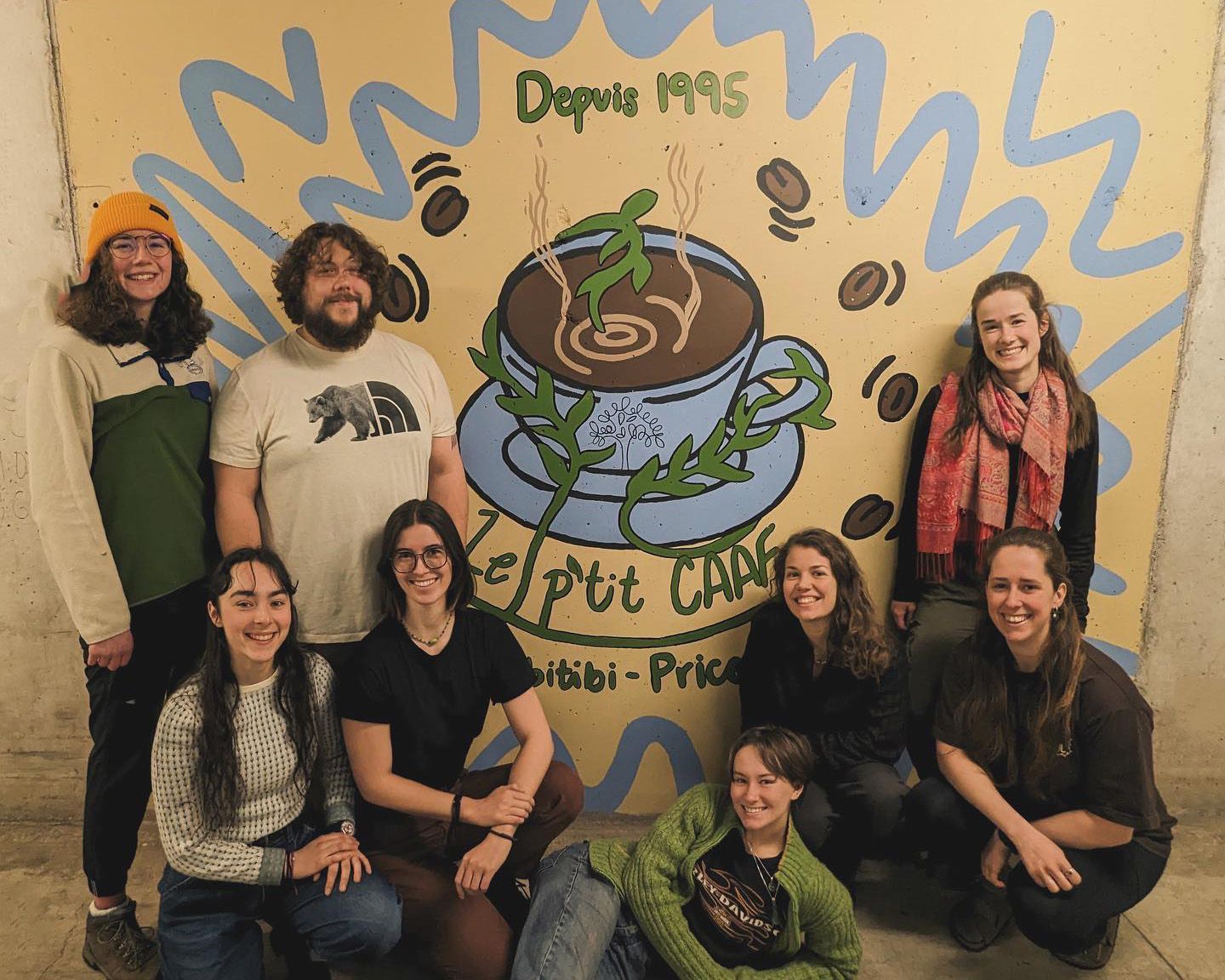 Groupe de 7 personnes devant un dessin sur un mur