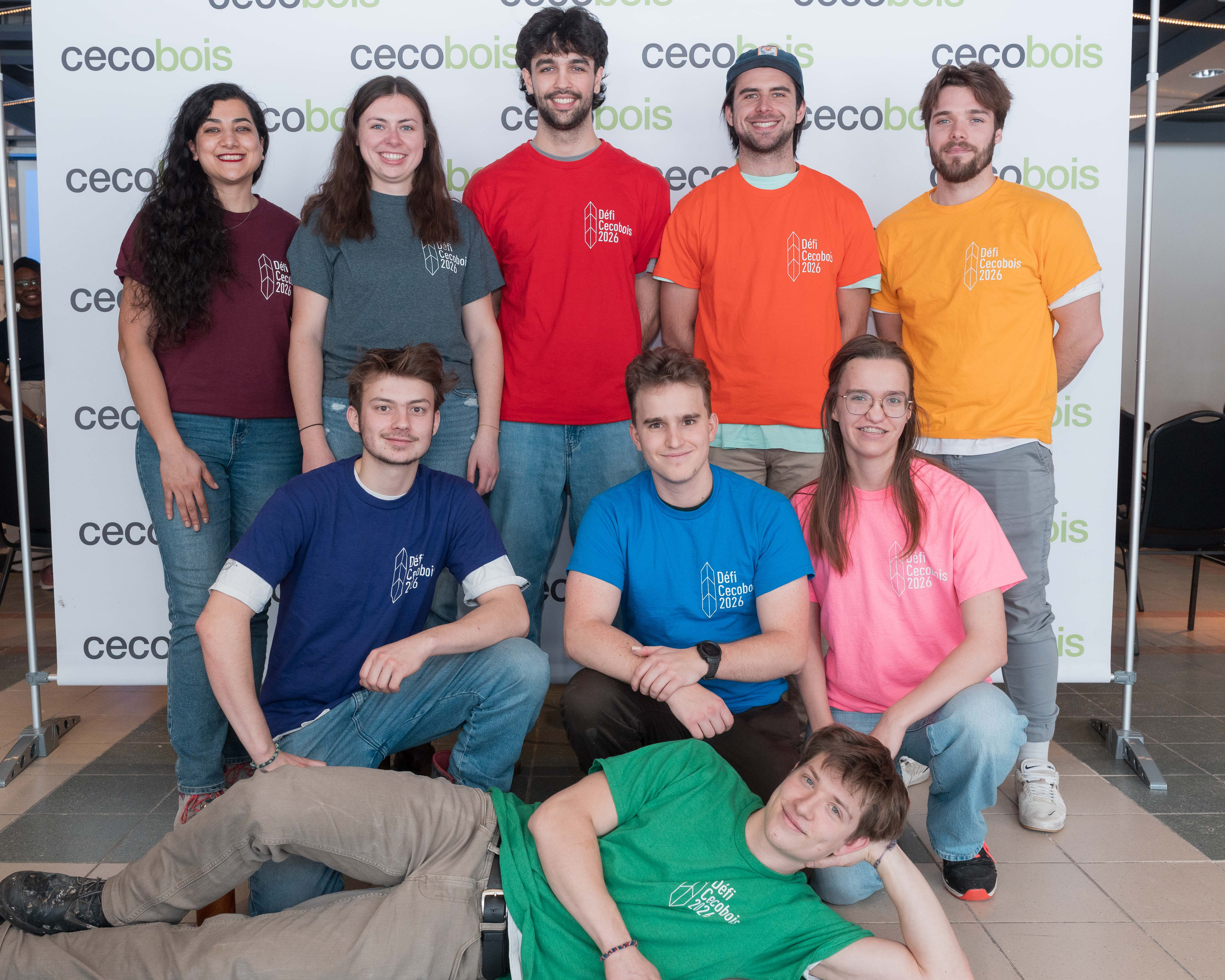 Groupe de jeunes avec tshirts colorés devant une bannière de cecobois
