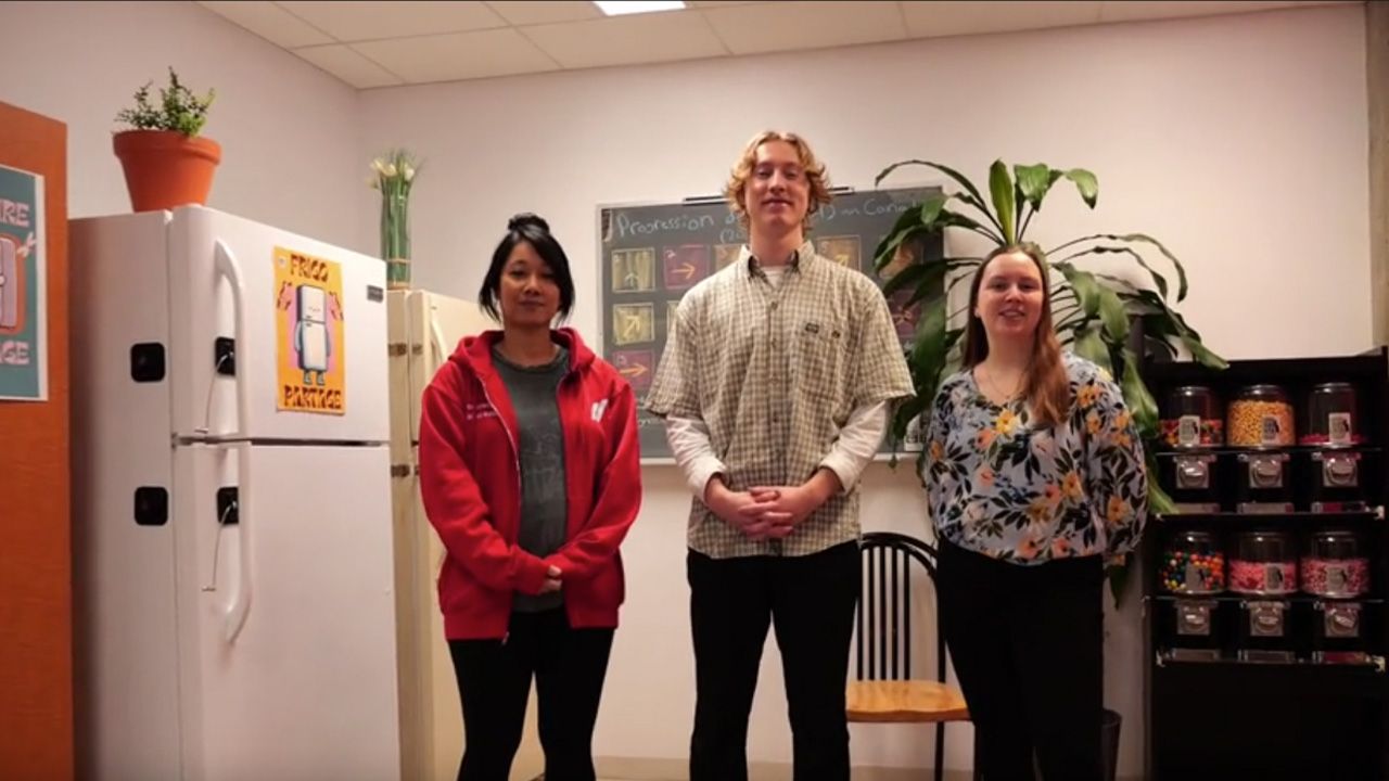 Trio d'étudiants devant un réfrigérateur