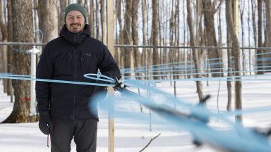 Homme dehors près de tubes d'érablières