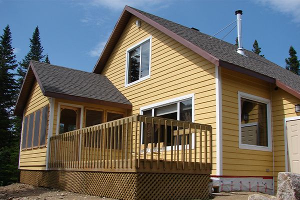 Chalet en bois jaune pâle avec patio vu de l'extérieur