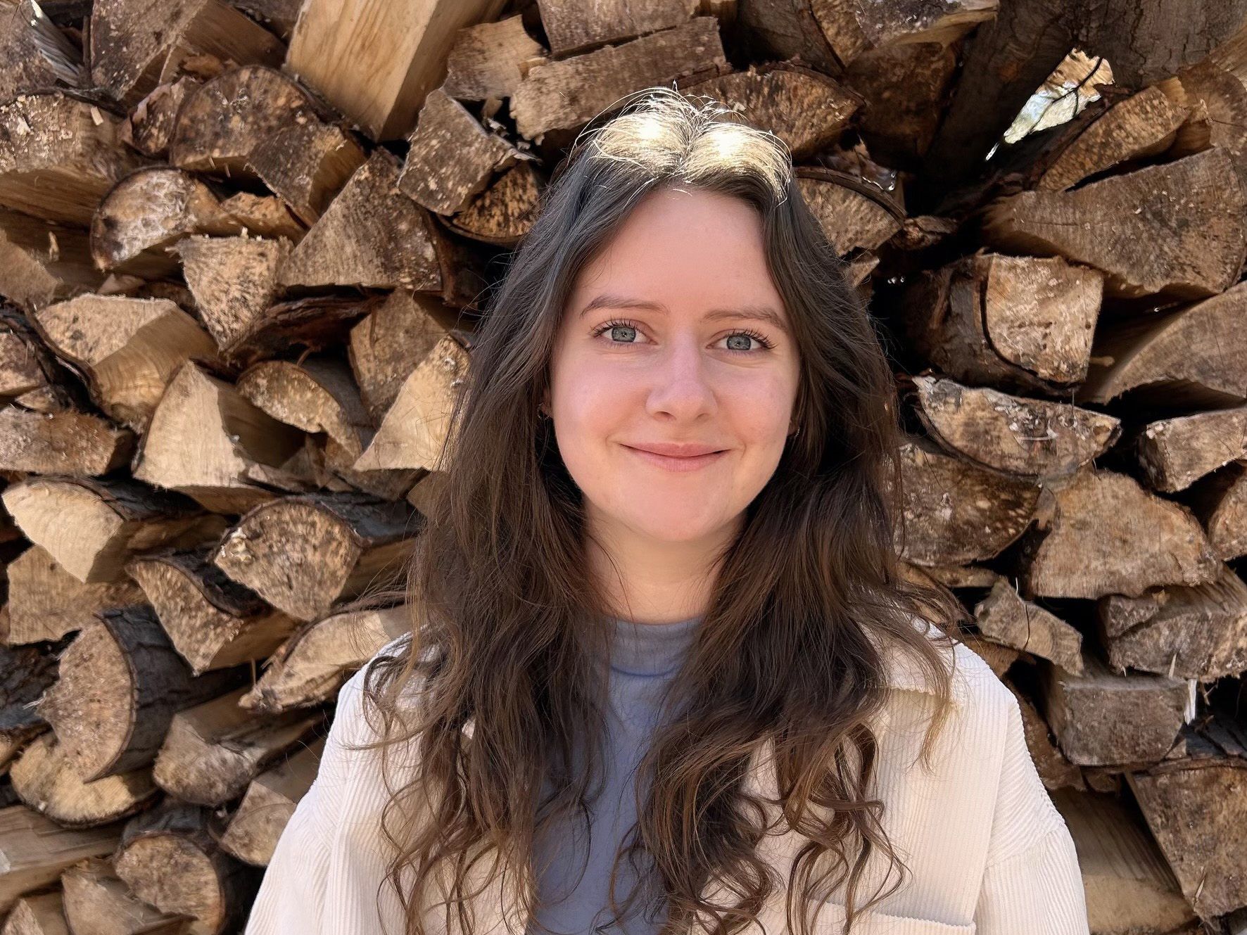Étudiante devant du bois cordé