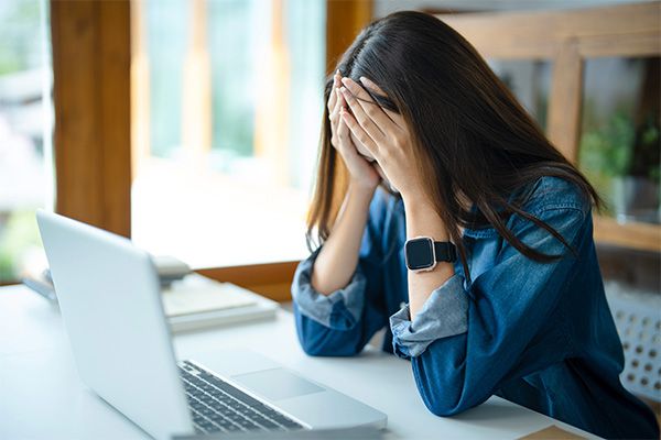 Santé psychologique Étudiante qui se prend la tête entre les mains en signe de découragement