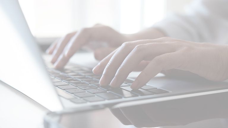 Mains tapant sur un clavier d'ordinateur portable