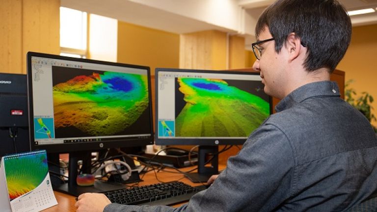 Étudiant en géomatique devant des ordinateurs