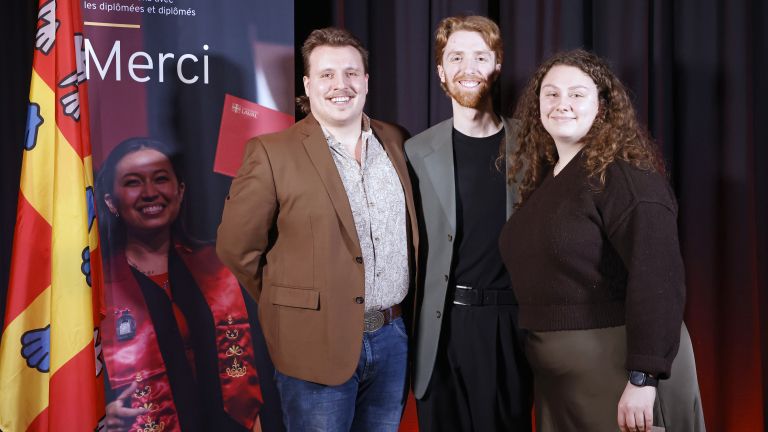 Trois étudiants devant un roll-up de l'UL