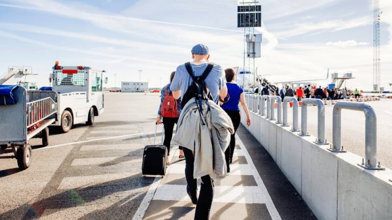 Des personnes marchent en sortant d'un avion